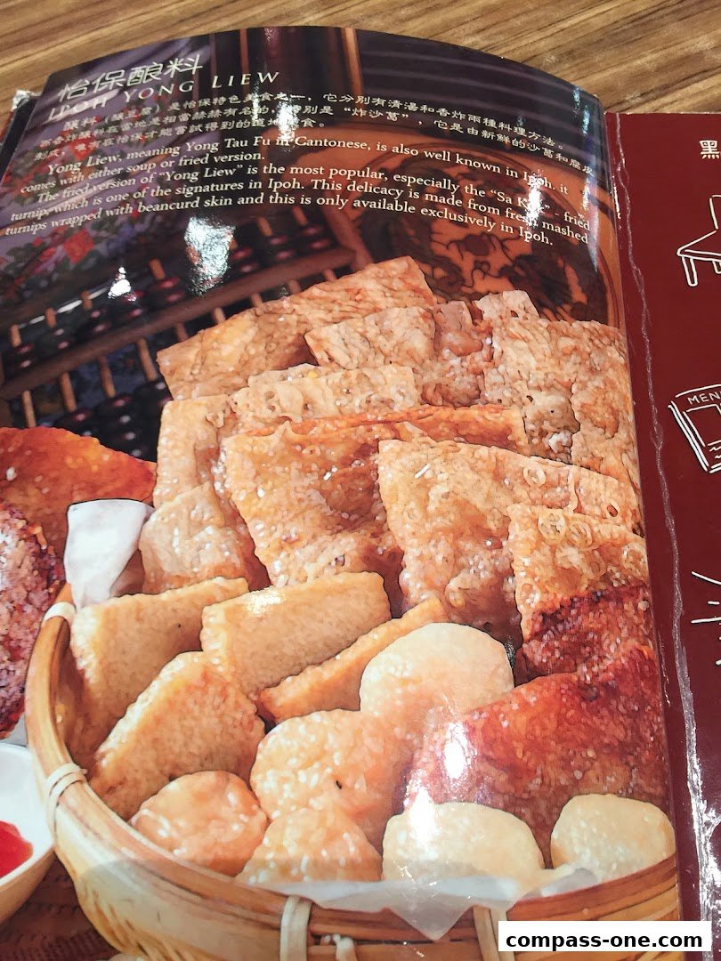 A close-up of a menu featuring a basket of fried Yong Liew, a popular Ipoh delicacy.