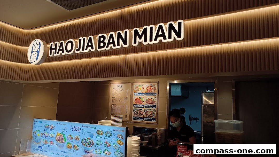 The exterior of a noodle shop with a prominent sign and menu displays.