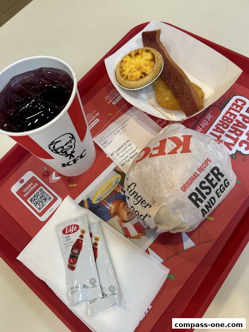 A KFC meal tray with a burger, drink, egg tart, hash brown, and bacon.