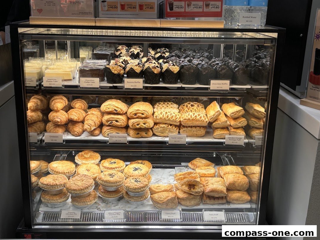 A display case filled with various pastries, cakes, and muffins at Kenangan Coffee.
