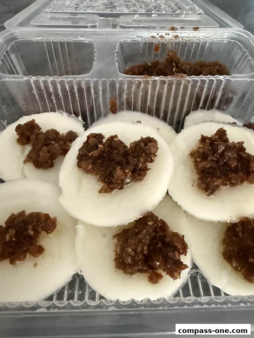 A close-up of Jian Bo Shui Kueh, a traditional snack, in a clear plastic container.