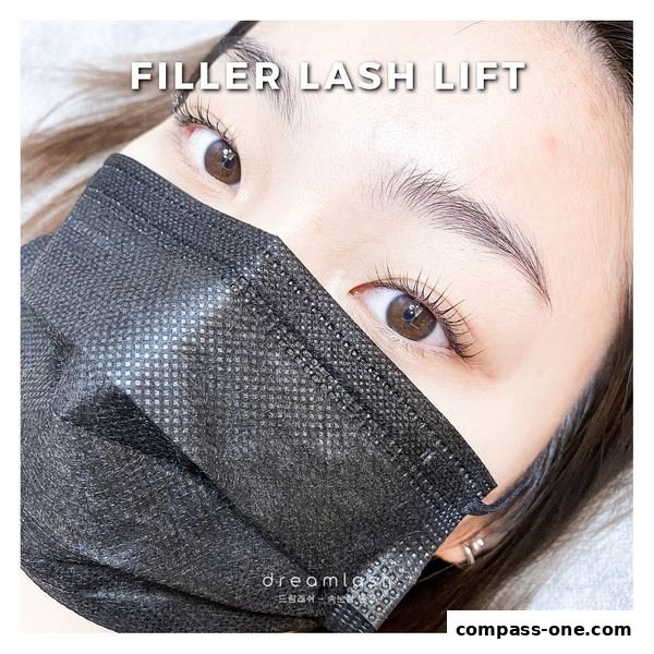 Close-up of a person's eyes with a lash lift, wearing a black face mask.