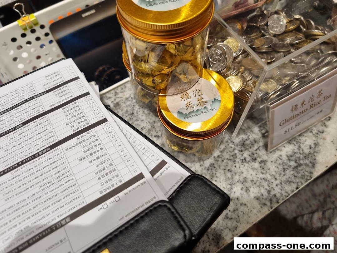 A close-up of a menu with Chinese and English text, alongside jars of tea and coins.