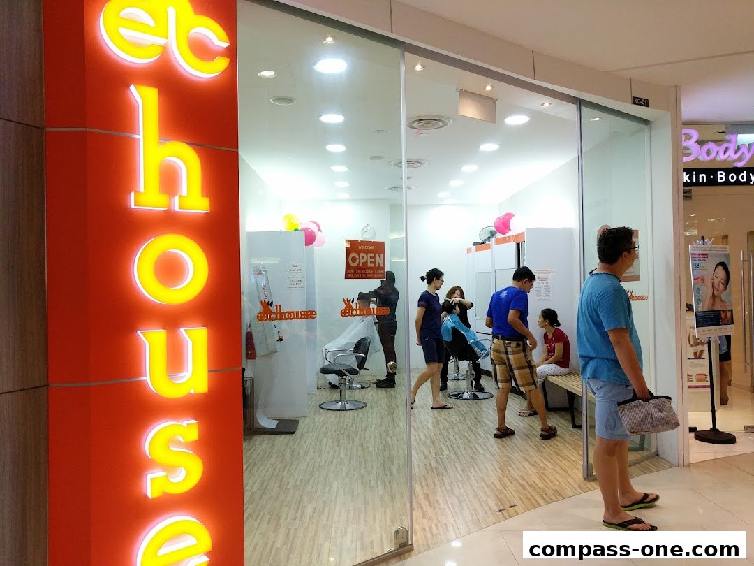 The exterior of EC House All Range Cuts, a hair salon with people inside getting haircuts.