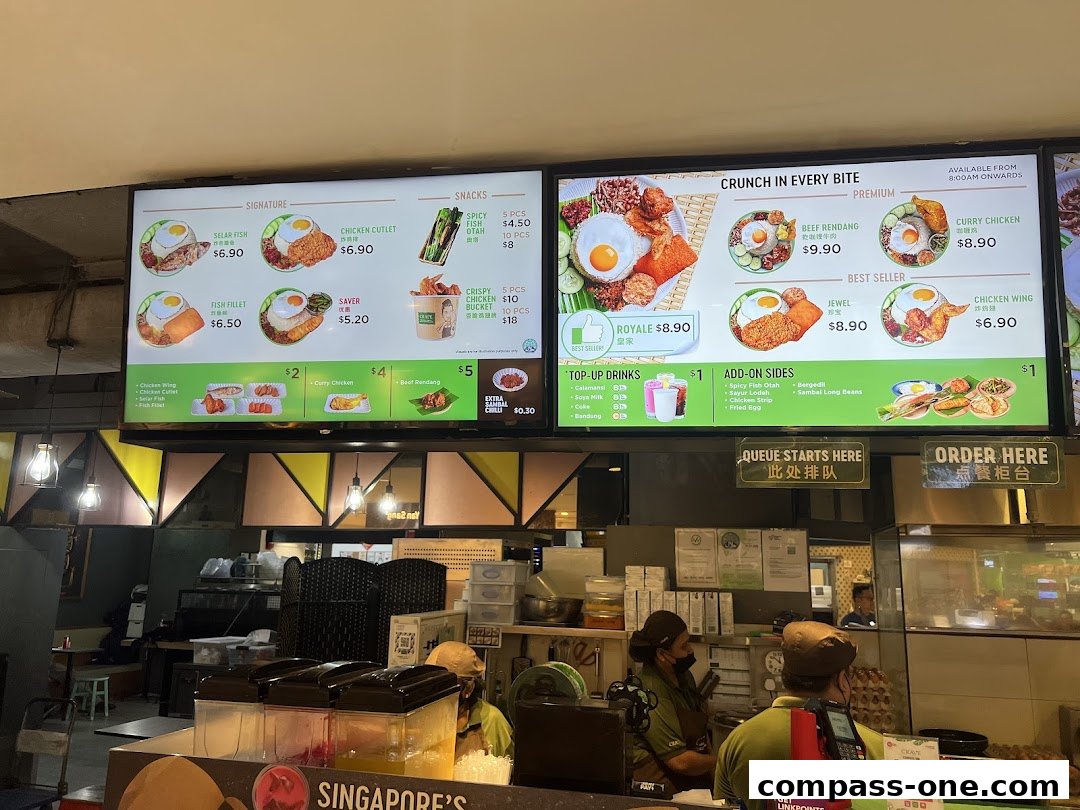 A digital menu board displaying various nasi lemak dishes and add-ons.