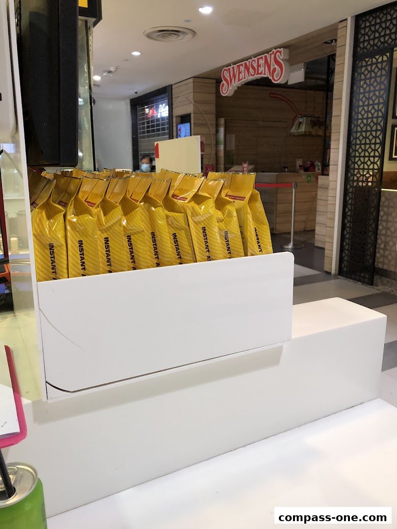 A display of yellow instant food packets in front of a Swensen's restaurant.