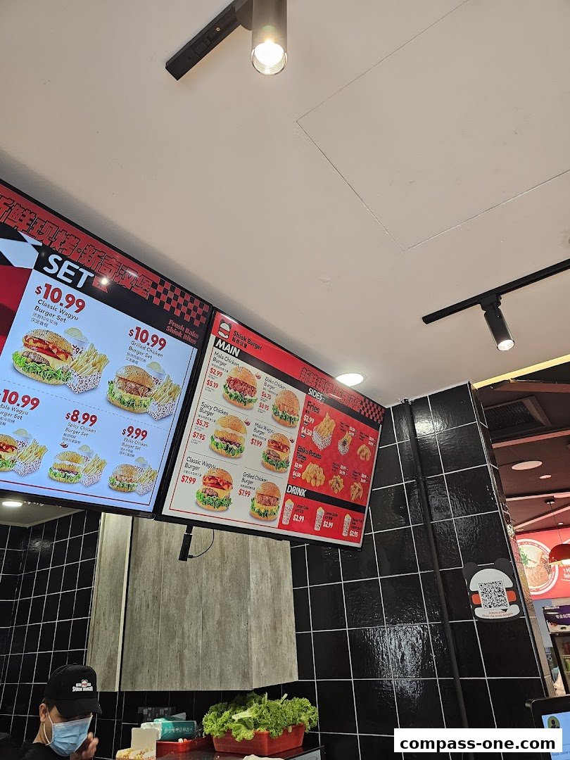 A menu board displaying various burger sets, mains, sides, and drinks at Shiok Burger.