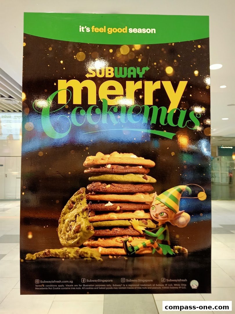 A Subway advertisement featuring a stack of cookies and a festive elf, promoting a holiday cookie promotion.