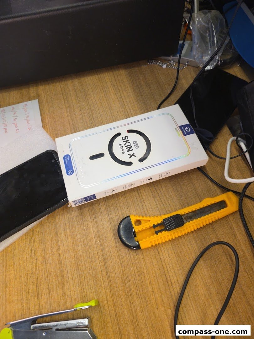 A box for a 'Skin X Pro Series' product is shown with a phone and tools on a wooden surface.