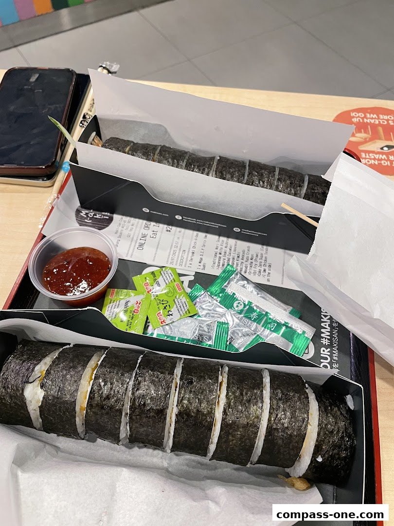 A close-up of Maki-San sushi rolls with dipping sauce and condiments.