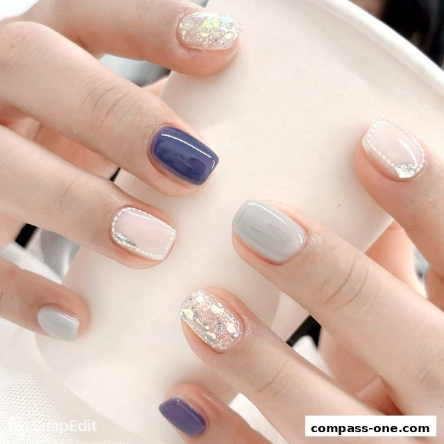 Close-up of hands with beautifully manicured nails in various pastel and glitter designs.