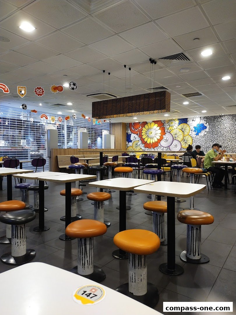 Interior of a McDonald's restaurant with tables, chairs, and colorful wall art.