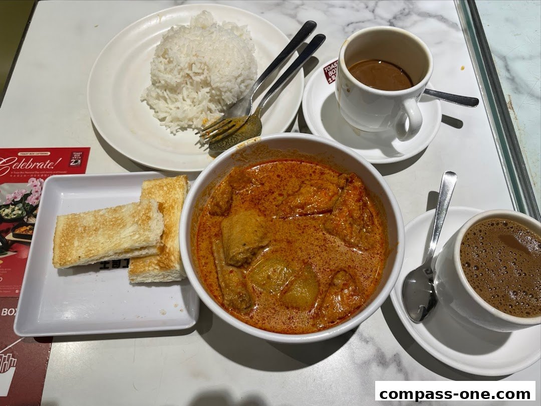 A delicious spread of curry chicken with rice, toast, and coffee from Toast Box.