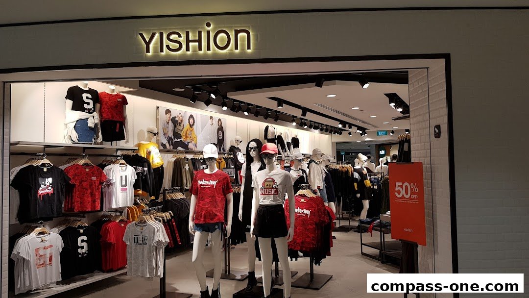 The entrance of a YISHION clothing store showcasing mannequins and apparel on display.