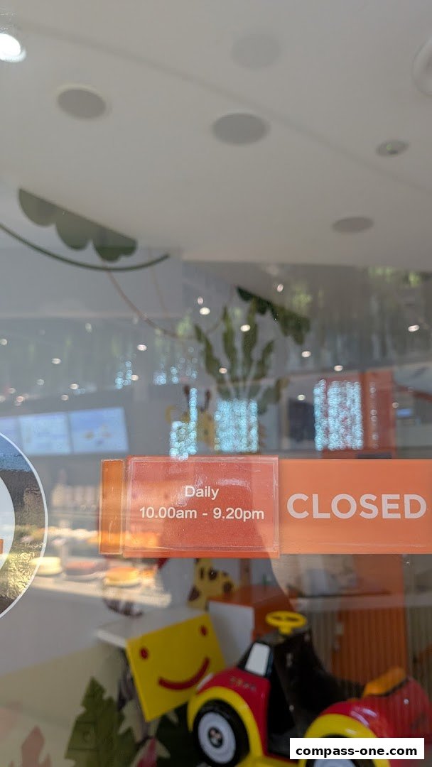 A shop window displays a 'CLOSED' sign and operating hours, with a toy car visible inside.