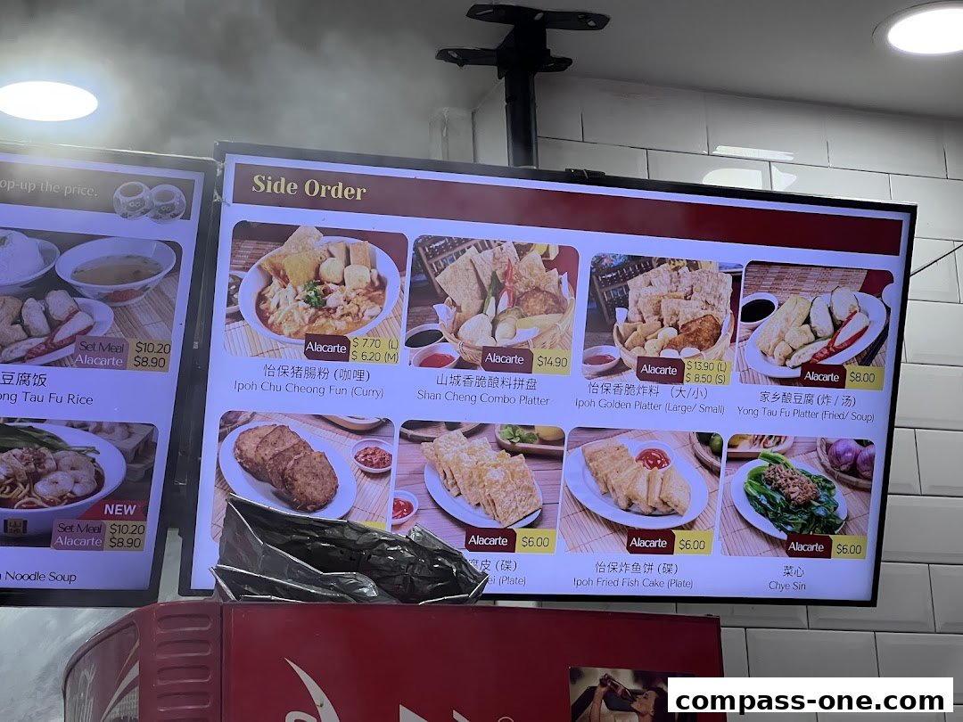 A digital menu board displaying various Ipoh delicacies and side orders with images and prices.