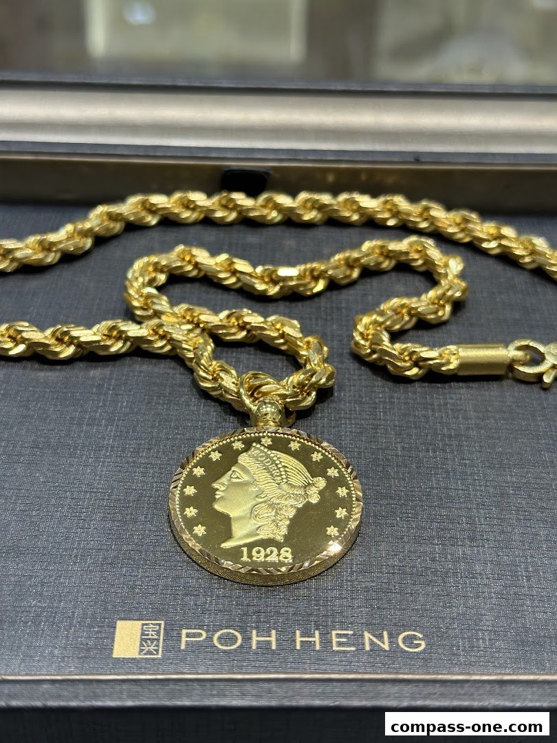 A close-up of a gold rope chain necklace with a vintage coin pendant.