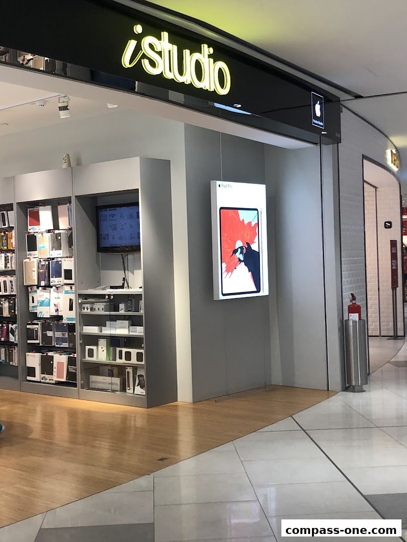 The iStudio store front displays Apple products and accessories on shelves and a large iPad Pro advertisement.