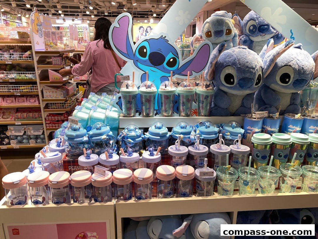 A display of Stitch-themed merchandise, including plush toys, water bottles, and cups.