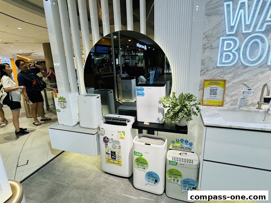 A retail display featuring various air purifiers and dehumidifiers with promotional signage.