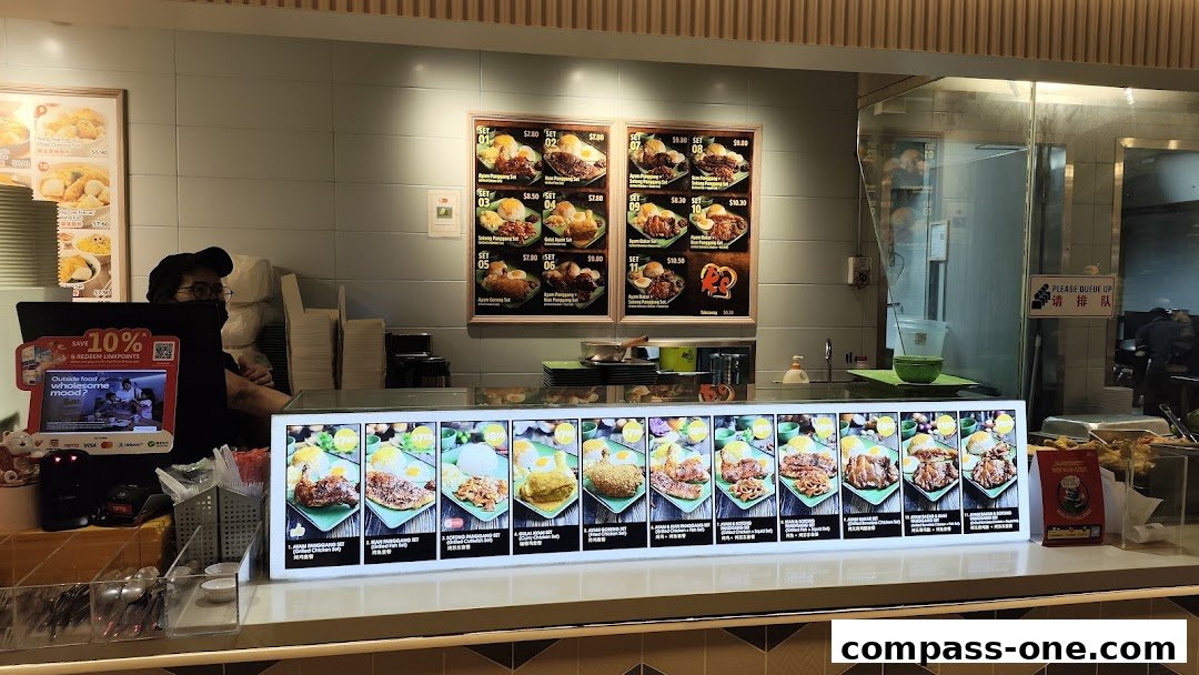 A food stall counter displaying various meal sets with prices and images.