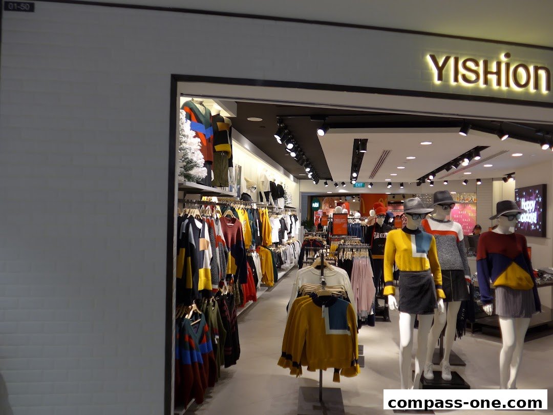 Yishion store interior with mannequins displaying colorful fashion and racks of clothing.