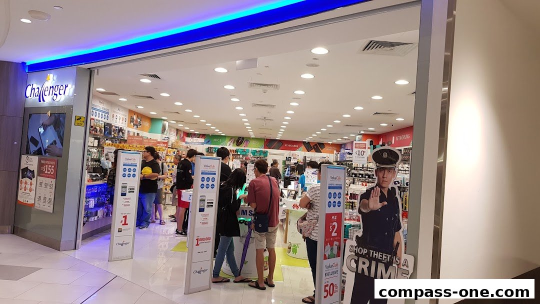 The entrance of a Challenger electronics store with customers browsing inside.