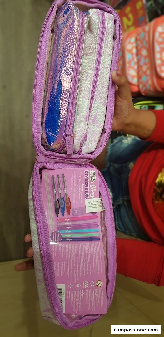 A person holds open a purple Smiggle pencil case filled with stationery and other pencil cases.