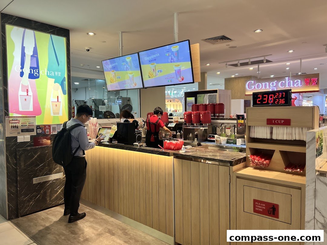 A customer orders bubble tea at a Gong Cha counter with staff preparing drinks.