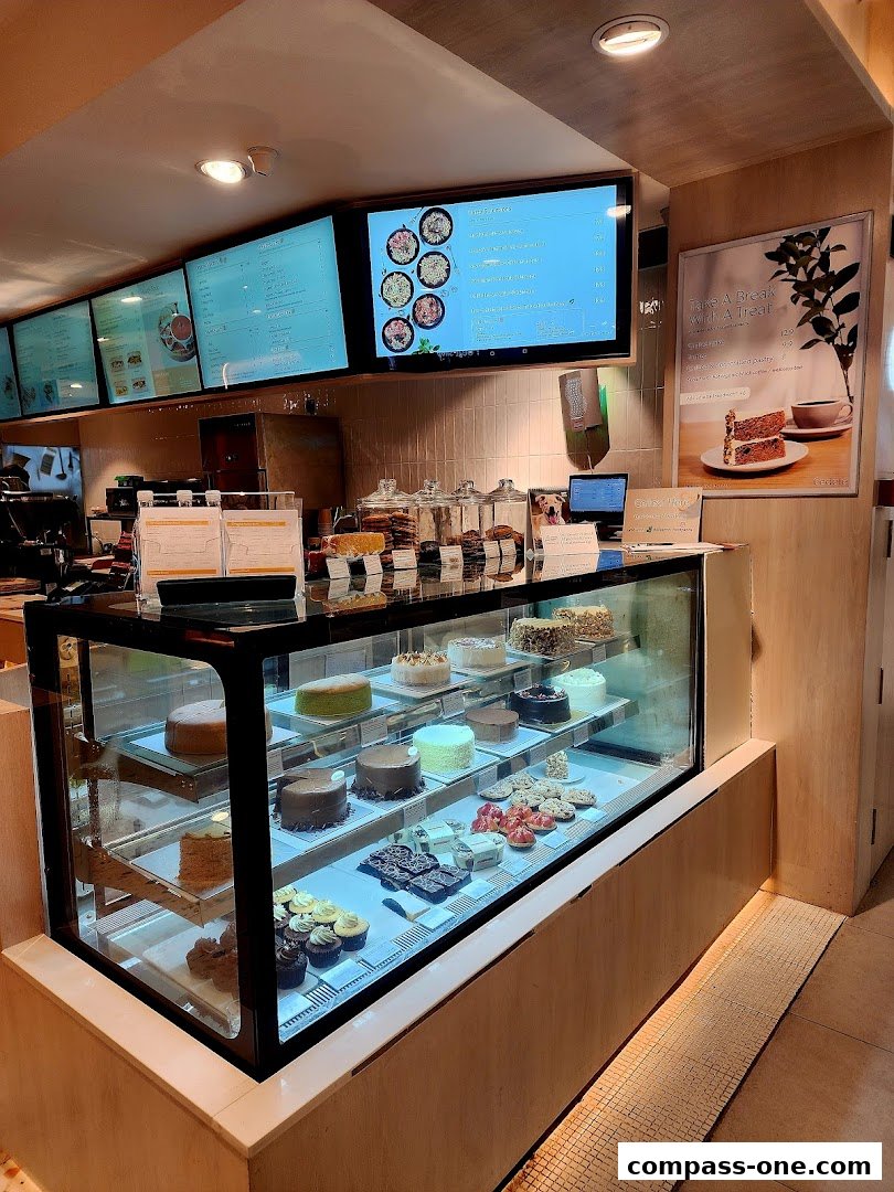 A display case filled with various cakes and pastries at Cedele Bakery Cafe.