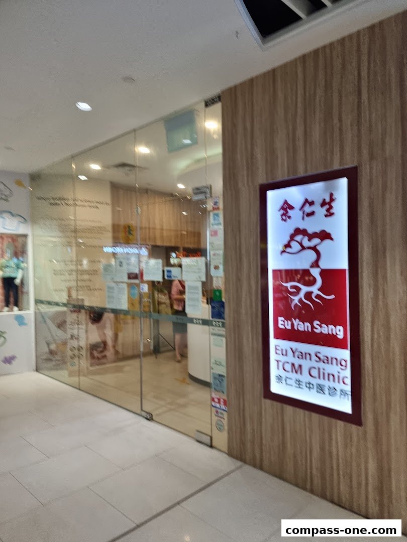 The entrance of Eu Yan Sang TCM Clinic with its illuminated sign and glass doors.