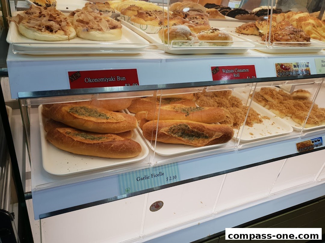 A display case filled with various freshly baked buns and bread at Four Leaves bakery.