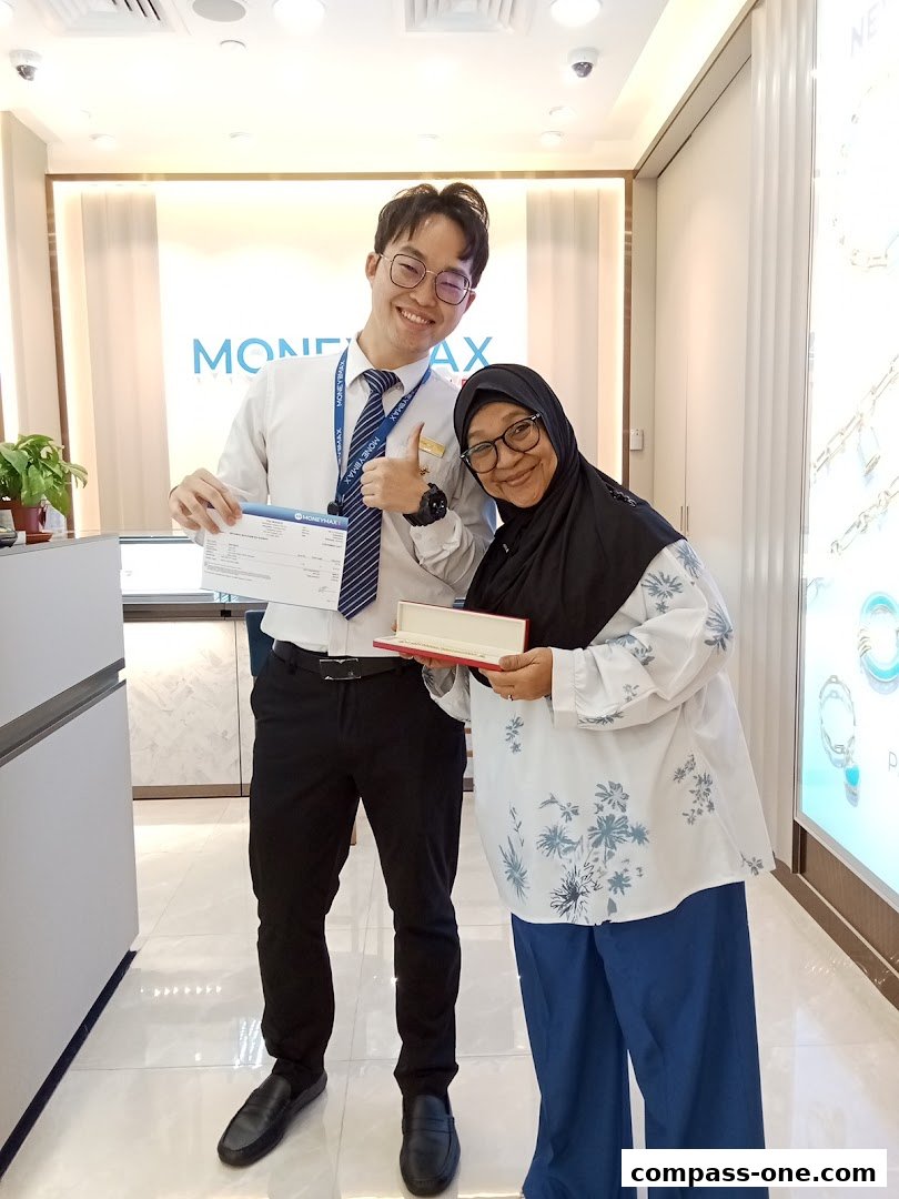 A male employee and a female customer smiling and posing for a photo inside a MoneyMax store.
