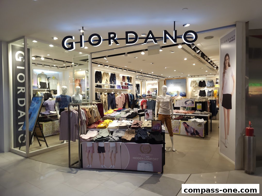 The Giordano store entrance displays a variety of men's and women's clothing on mannequins and racks.