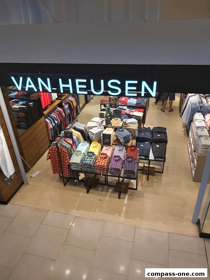 Interior view of a Van Heusen store showcasing a variety of men's shirts on display.