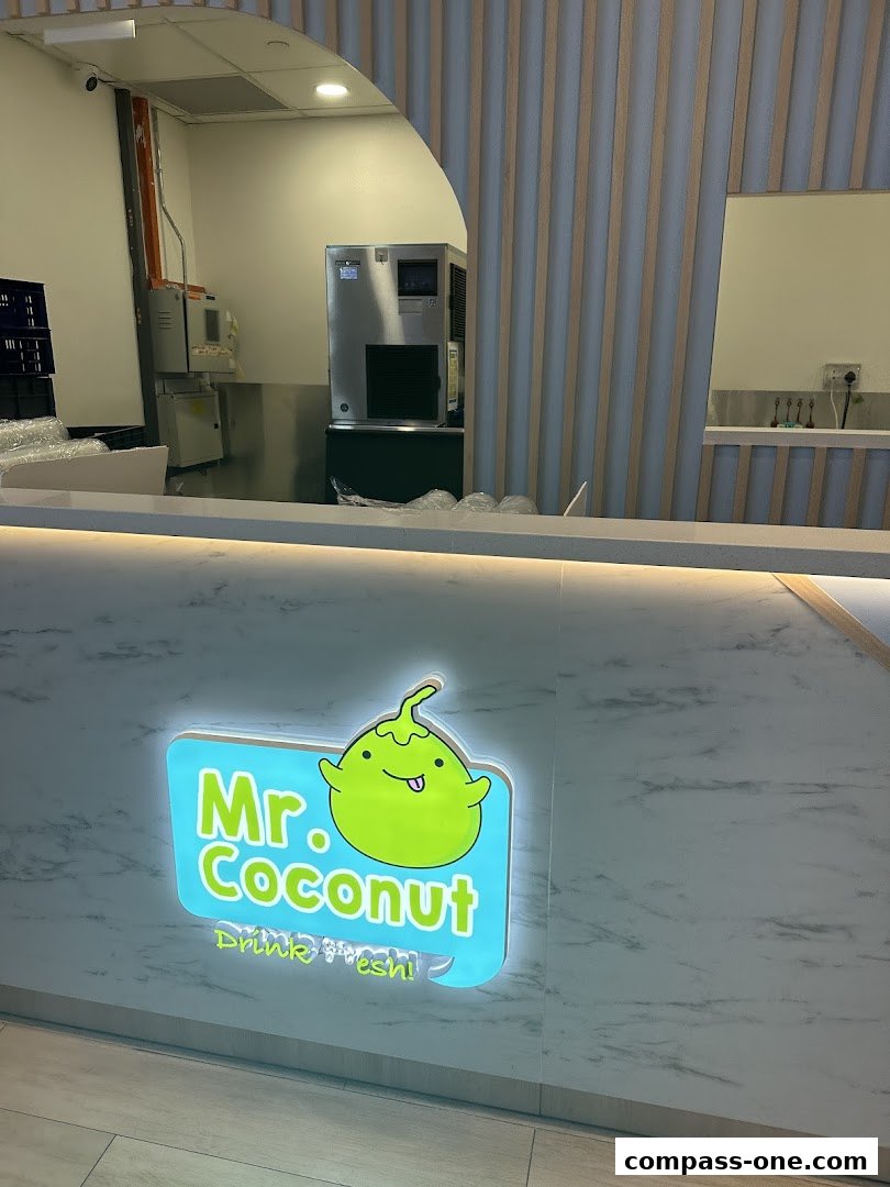 The Mr. Coconut shop front features a bright, illuminated sign with a cute coconut character.