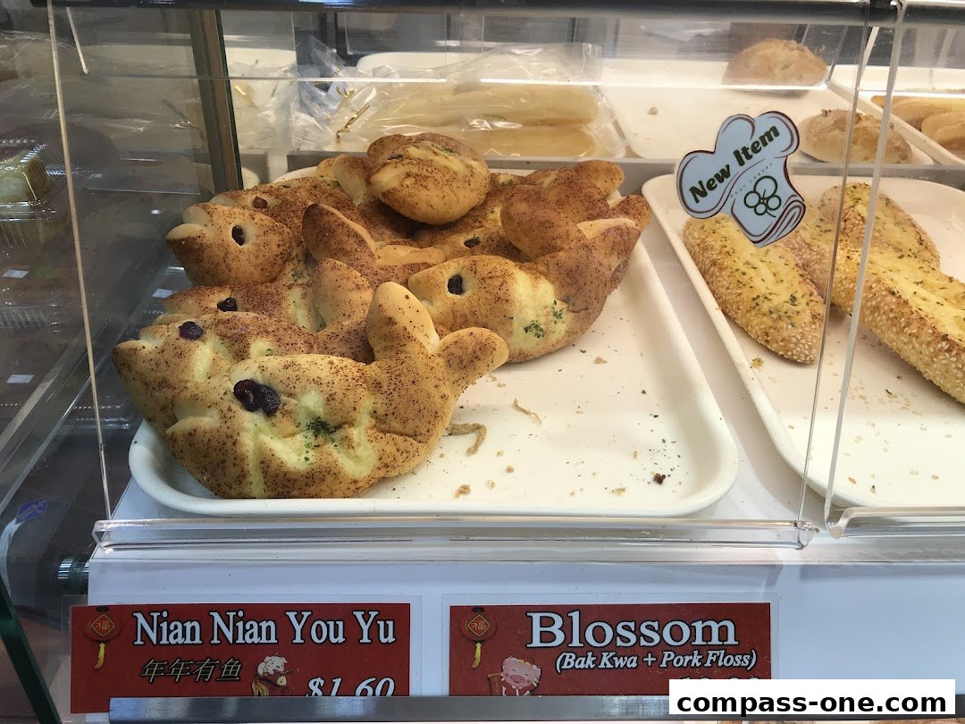 A display case filled with freshly baked bread, including fish-shaped buns and savory rolls.
