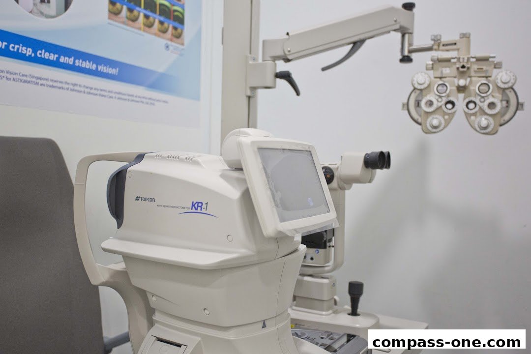 An eye examination room with advanced optical equipment and a poster about vision.