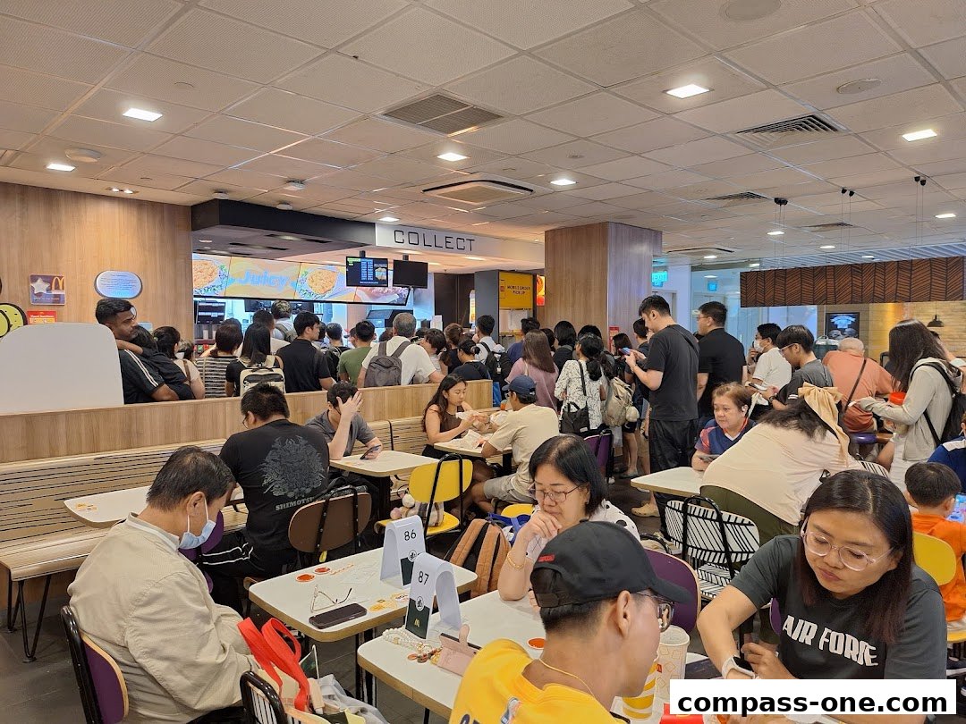 A busy McDonald's restaurant with many customers queuing and dining.