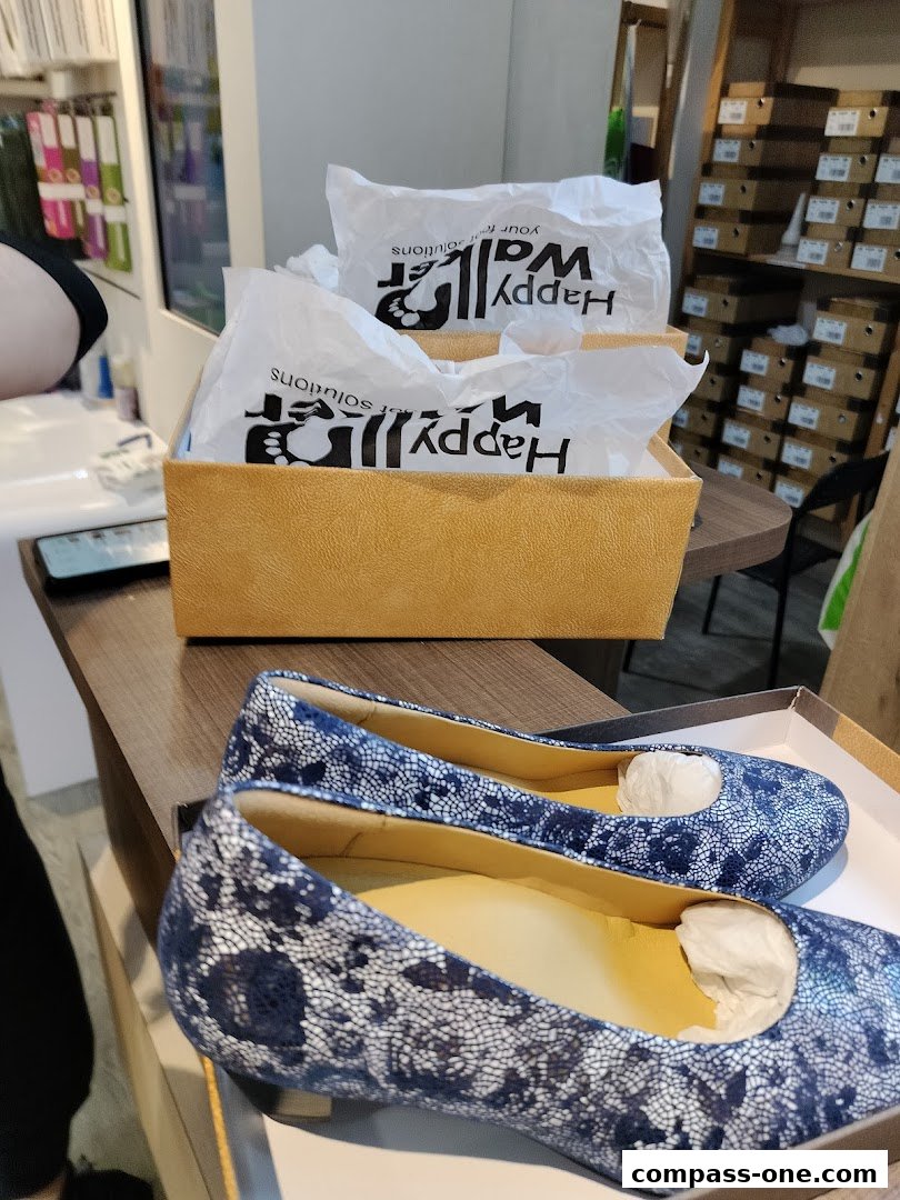 A pair of stylish blue patterned women's shoes displayed in a box with branded tissue paper.