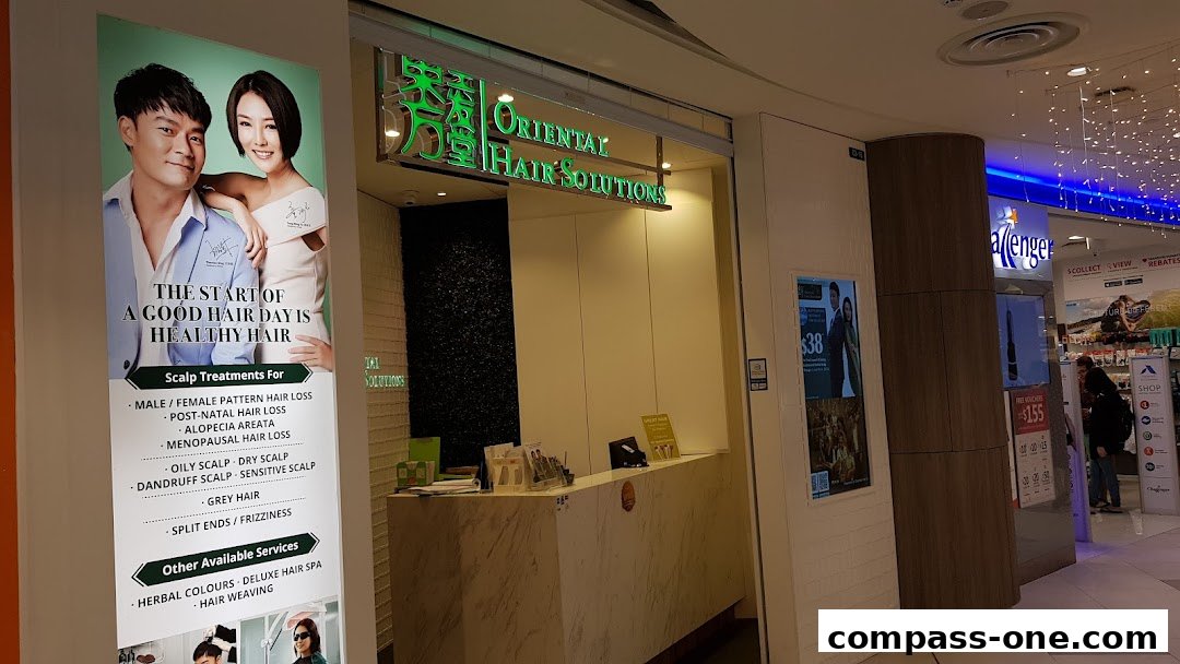 The entrance of Oriental Hair Solutions, featuring a promotional poster and the shop's signage.