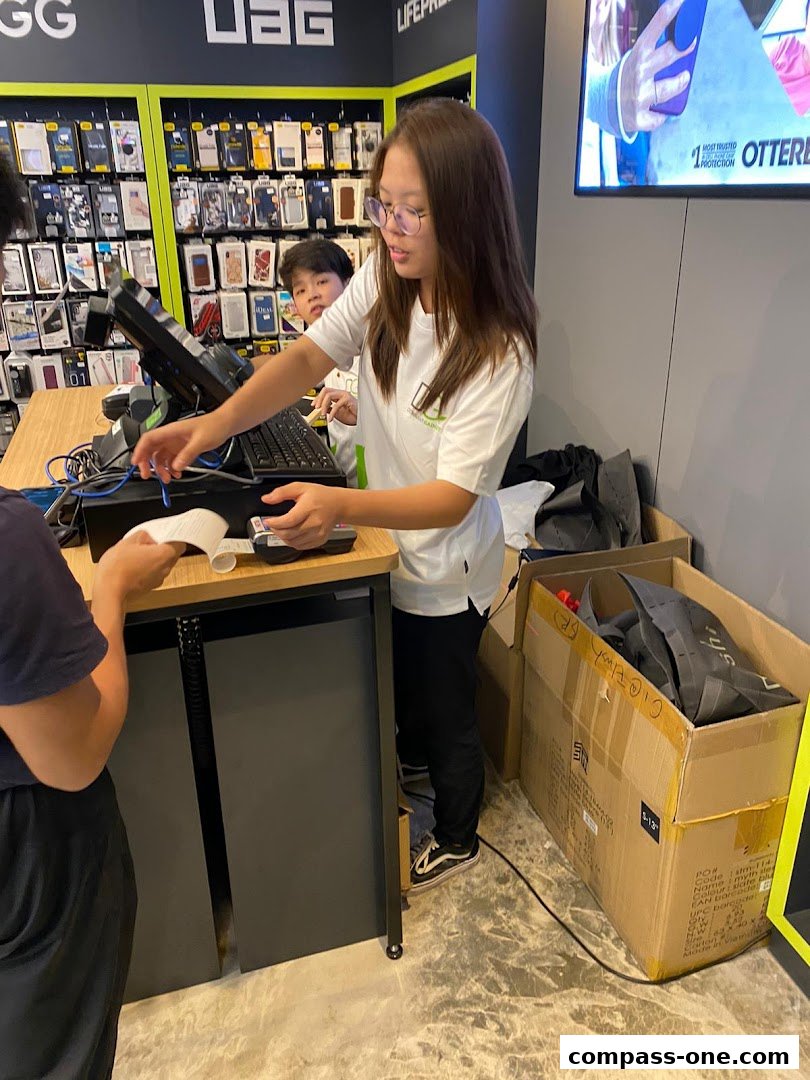 A shop assistant is serving a customer at a counter in a digital gadgets store.