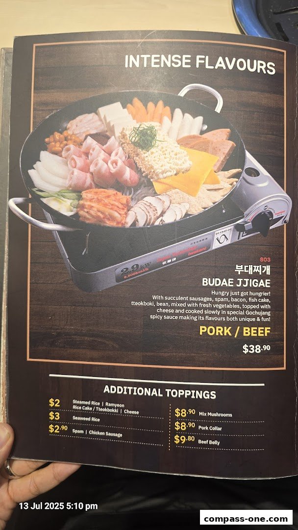 A menu page showcasing Budae Jjigae with various ingredients and additional toppings.