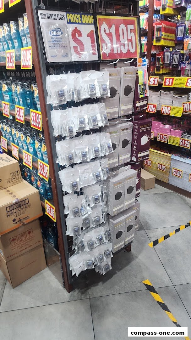 A retail display featuring dental floss, face masks, and other personal care items with price tags.