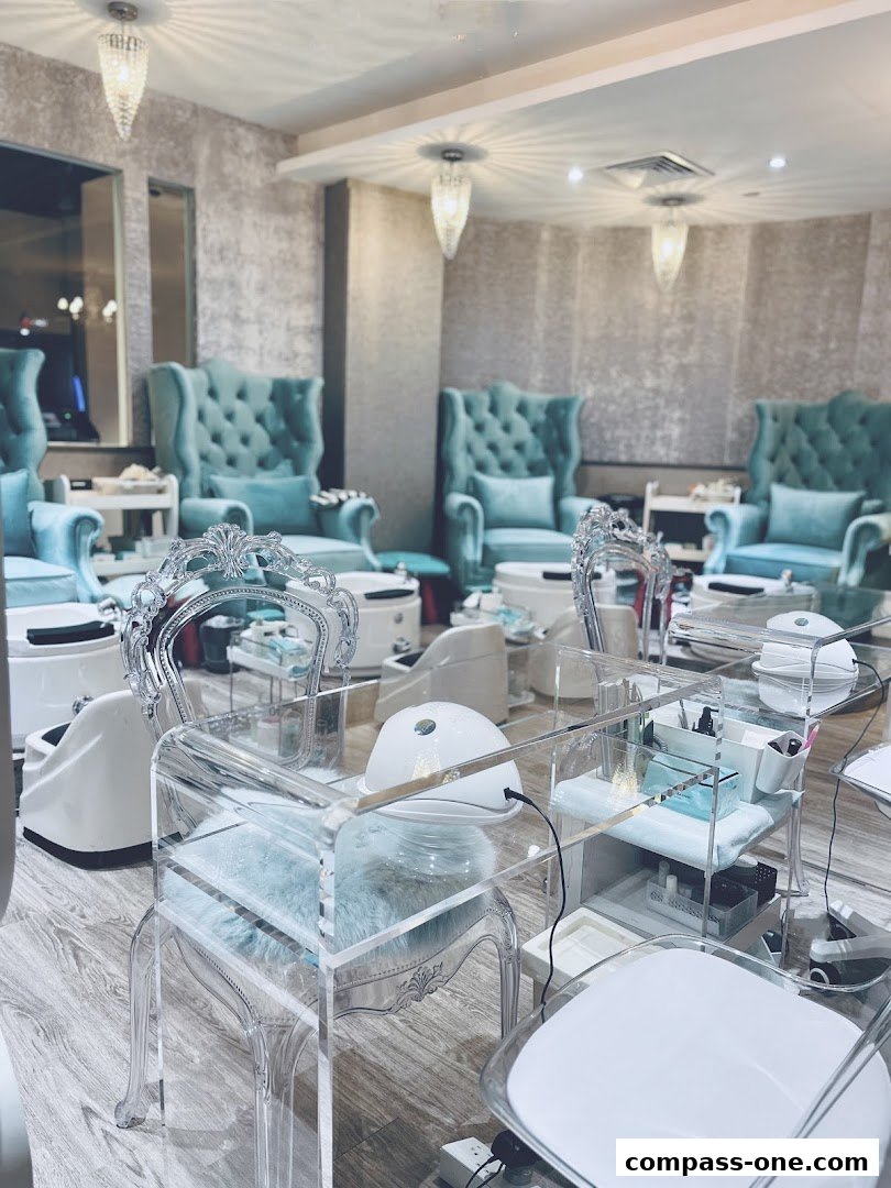 Luxurious nail salon interior with plush teal chairs and modern manicure stations.