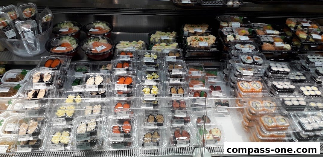 A display case filled with various pre-packaged sushi and sashimi selections.