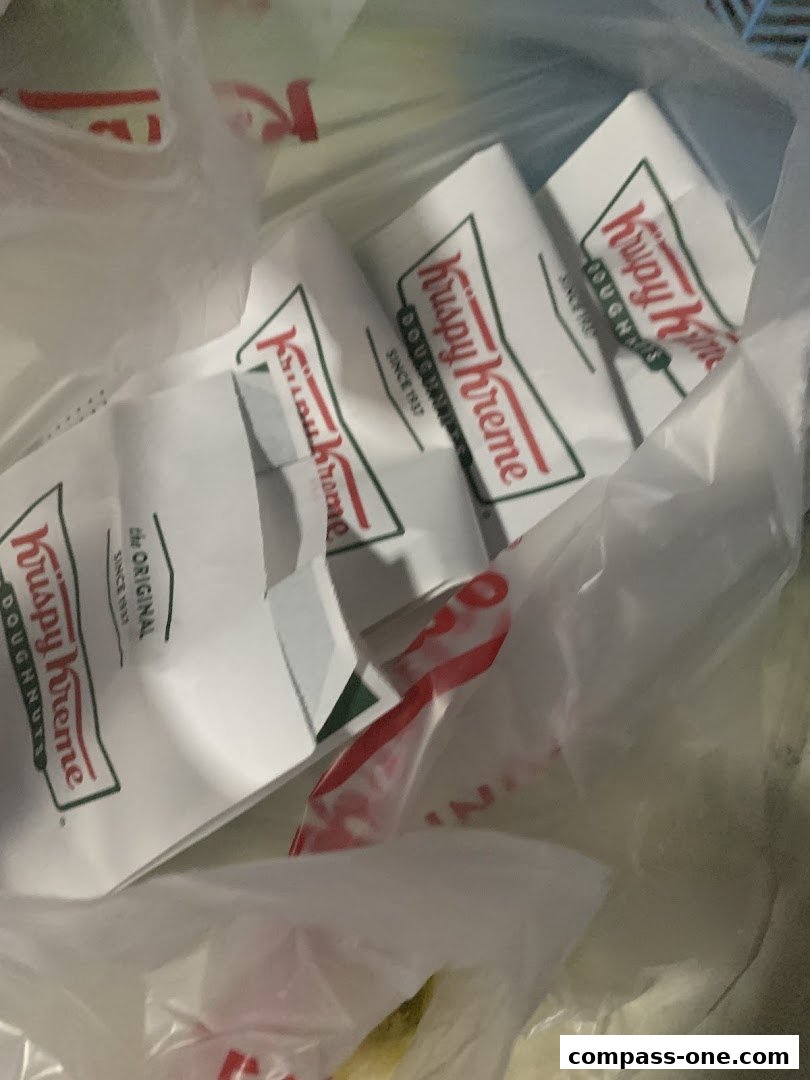Several Krispy Kreme doughnut boxes are visible inside a plastic bag.