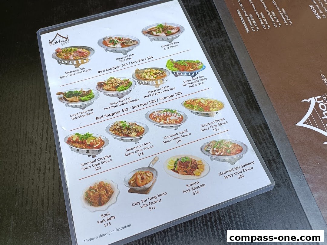 A menu from Nakhon Kitchen showcasing various Thai seafood and meat dishes with enticing images.