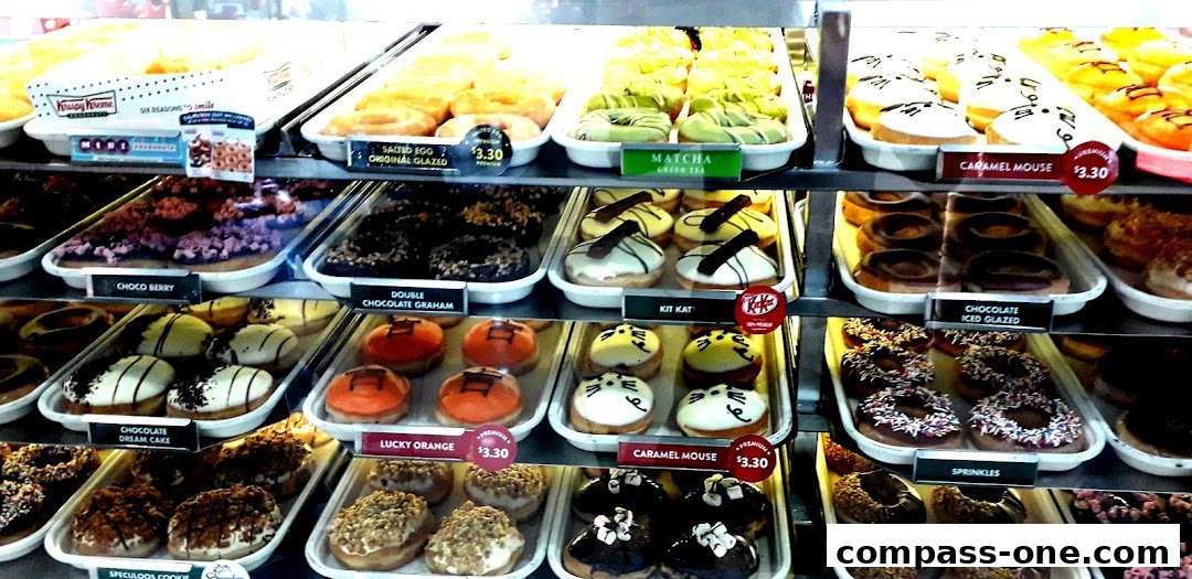 A display case filled with a variety of colorful and delicious Krispy Kreme donuts.