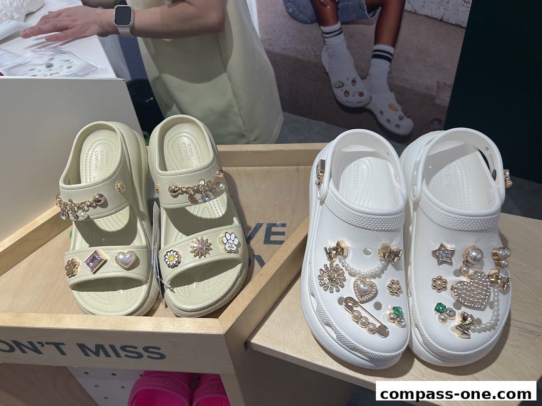 Crocs shoes decorated with charms and pearls displayed on shelves.